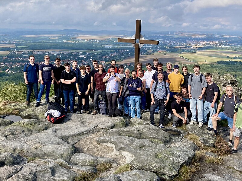 Ein Panoramablick vom Töpferberg zeigt die beeindruckende grüne Landschaft. Neben einer Wandergruppe sind Felsformationen zu sehen.
