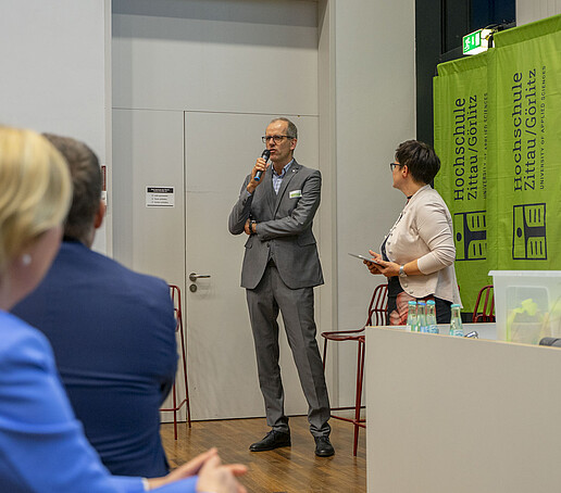 Der Vorsitzende des Fördervereins spricht in ein Mikrofon zum Publikum.