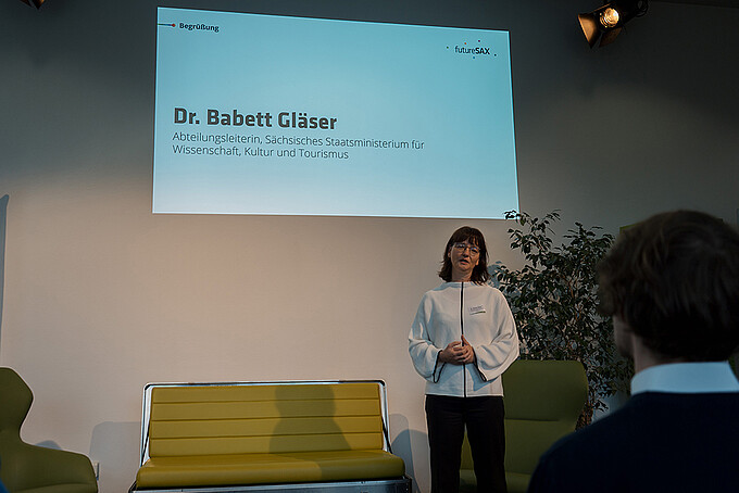 Eine Rednerin spricht vor Publikum.