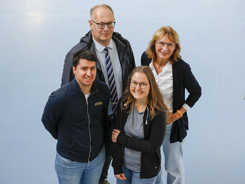 Das Projektteam steht im Foyer von Haus Z IV und schaut nach oben in die Kamera.