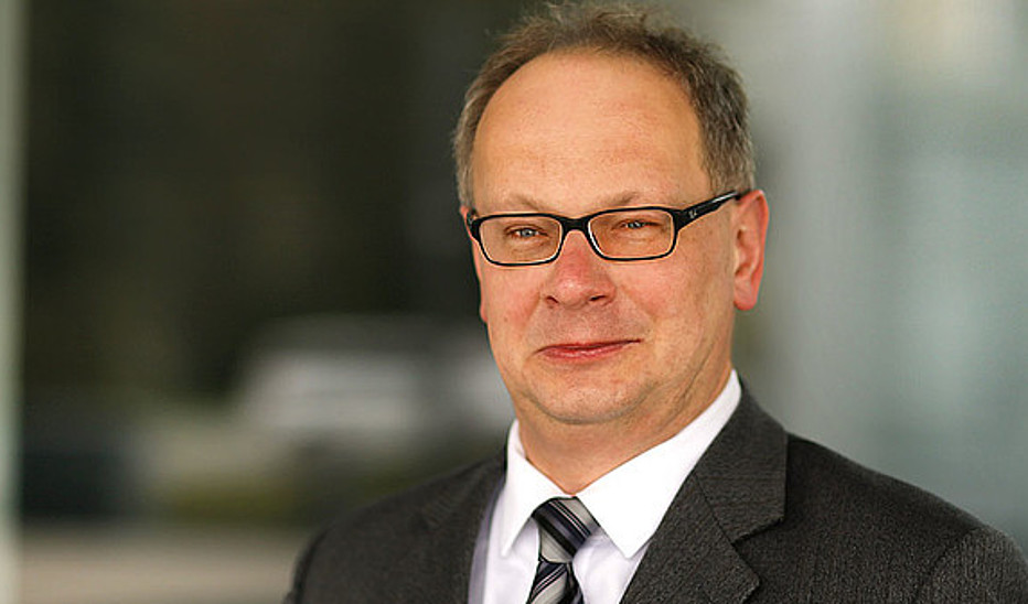 Foto: Jens Freudenberg Prof. Meißner trägt Brille und Anzug mit Krawatte. Er lächelt in die Kamera.