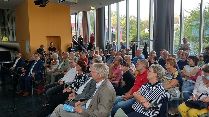 In der Aula der HSZG sitzen viele Menschen auf Stuhlreihen und blicken in Richtung Präsentationsfläche.